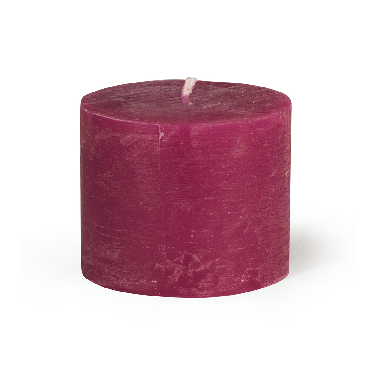 Une bougie de jardin cylindrique, de couleur rouge foncé et à la surface rugueuse, repose sur un socle blanc. La mèche est placée au centre. La bougie est teintée dans la masse et présente un aspect rustique.