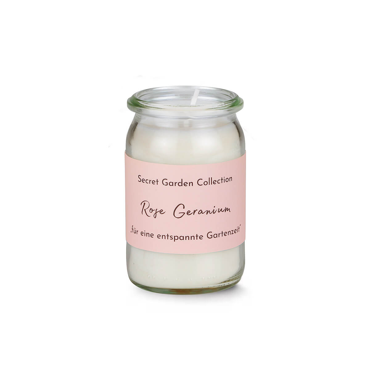 Eine unangezündete weiße Duftkerze in zylindrischem Glas mit rosa Etikett. Darauf steht "Secret Garden Collection" und "Rose Geranium" in schwarzer Schrift, gefolgt von "für eine entspannte Gartenzeit". Docht zentriert.