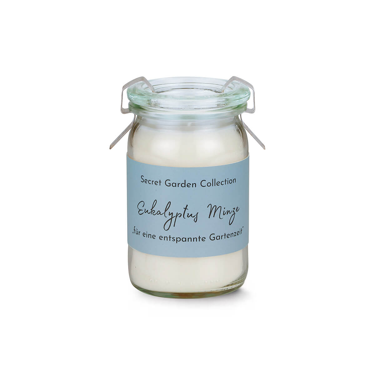 Cremeweiße Duftkerze in kleinem, durchsichtigem Glasgefäß mit hellblauem Etikett: „Secret Garden Collection“, „Eukalyptus Minze“ und „für eine entspannte Gartenzeit“. Glas mit offenem Metallbügelverschluss.
