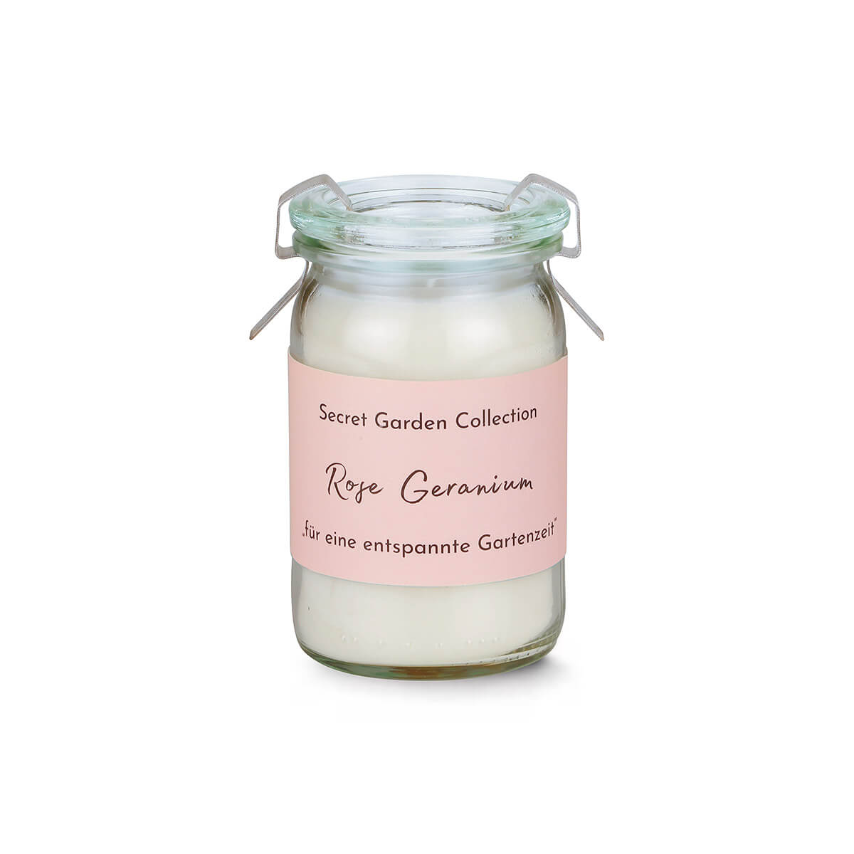 Kleines, durchsichtiges Glasgefäß mit weißem Kerzenwachs und rosafarbenem Etikett. Aufdruck: 'Secret Garden Collection', darunter 'Rose Geranium' und 'für eine entspannte Gartenzeit'. Mit Metallbügelverschluss.
