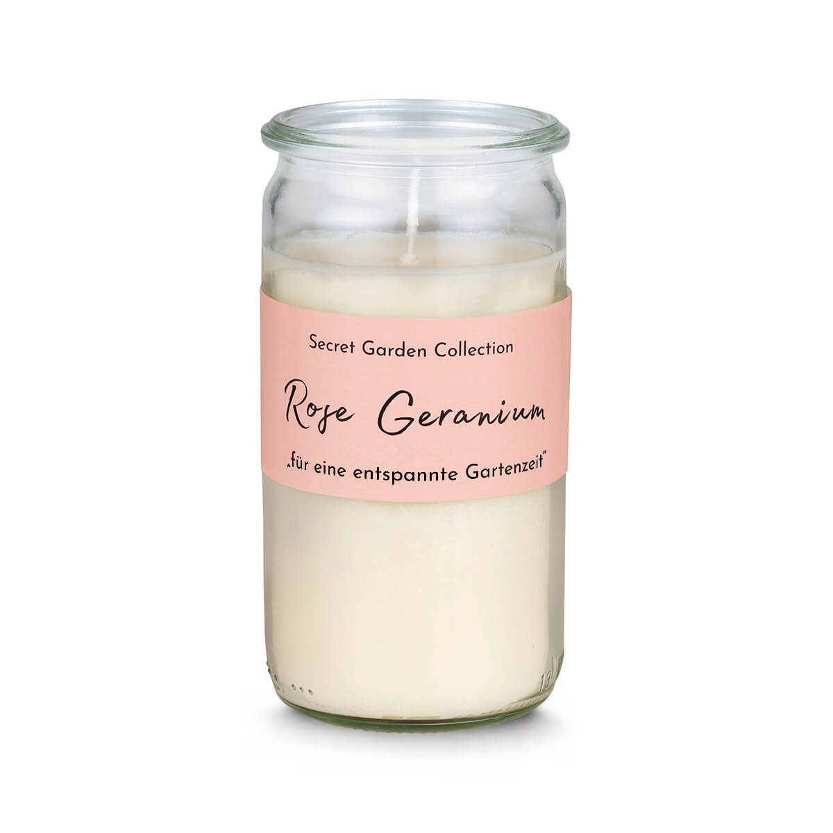 Candela color crema in vaso di vetro cilindrico con etichetta rosa. Riporta «Secret Garden Collection», «Geranio rosa» in caratteri decorativi e «per rilassanti momenti in giardino». Stoppino visibile.