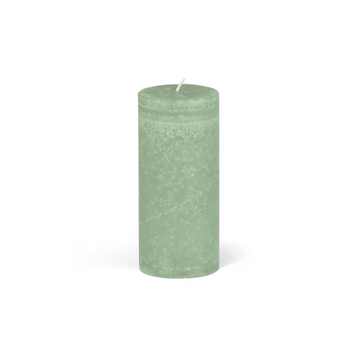 A single, cylindrical pillar candle in light green stands in the centre of a white background. The wick is positioned at the top centre. The texture of the candle is slightly uneven. The light casts a small shadow on the left-hand side.