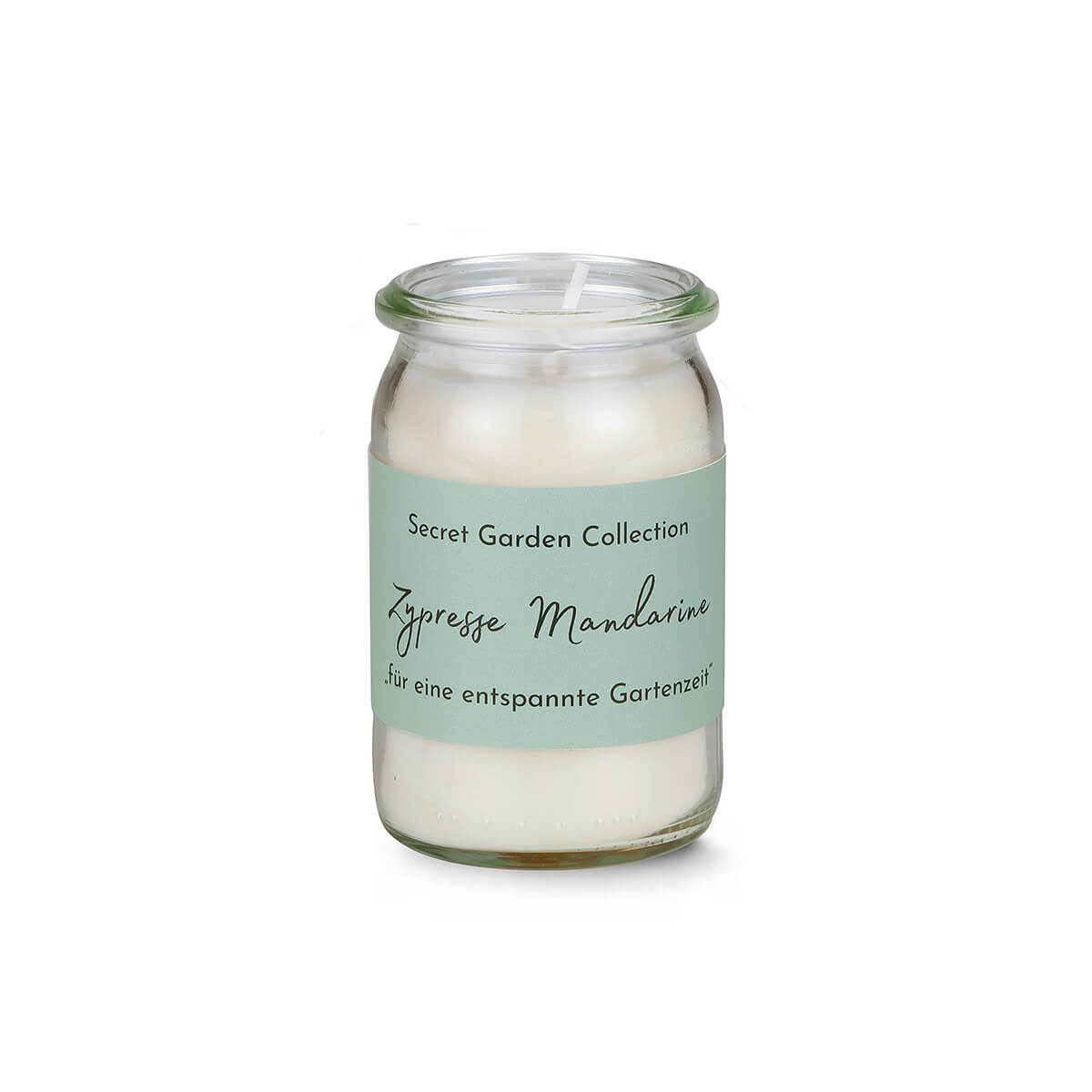Weiße Duftkerze in kleinem, transparentem Glas mit hellgrünem Etikett. Aufschrift: „Secret Garden Collection“, „Zypresse Mandarine“ in geschwungener Schrift und „für eine entspannte Gartenzeit“. Docht ragt aus dem Wachs.