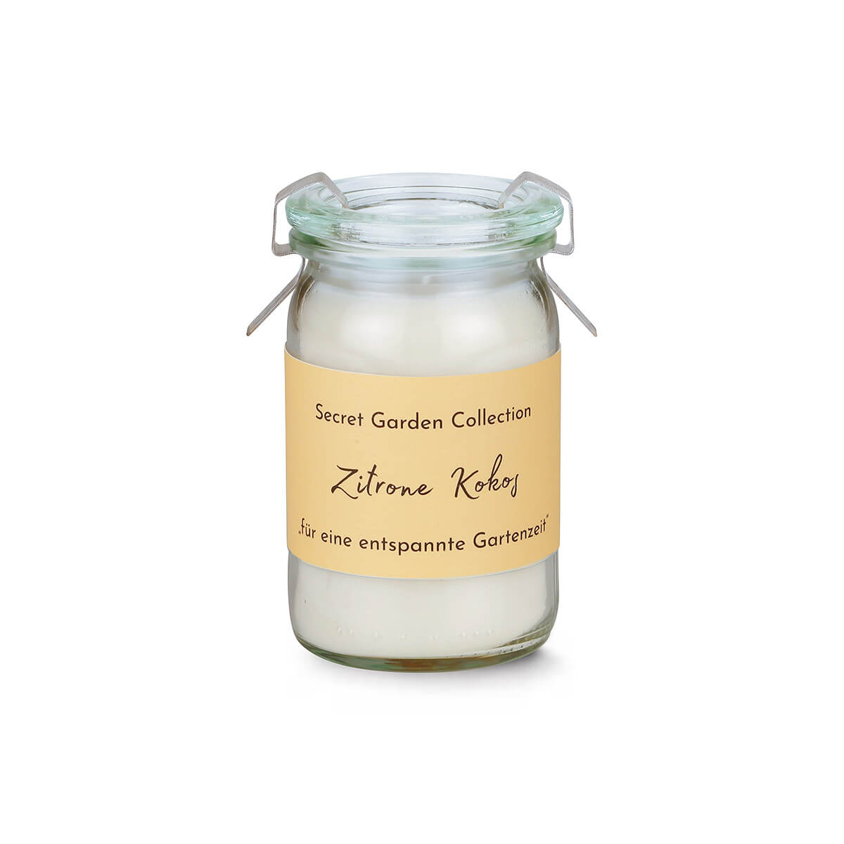 Duftkerze in kleinem, durchsichtigem Glas mit Metallbügelverschluss. Beiges Etikett mit "Secret Garden Collection" und "Zitrone Kokos" weist auf den Duft hin. Weiße Kerze, bereit zum Anzünden für entspannte Gartenzeit.