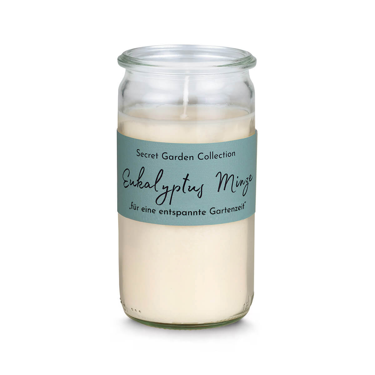 Candela alta e cilindrica in vetro trasparente, riempita con cera color crema. Etichetta verde menta con la scritta «Secret Garden Collection Eucalipto e Menta per momenti di relax in giardino». Stoppino non acceso visibile.