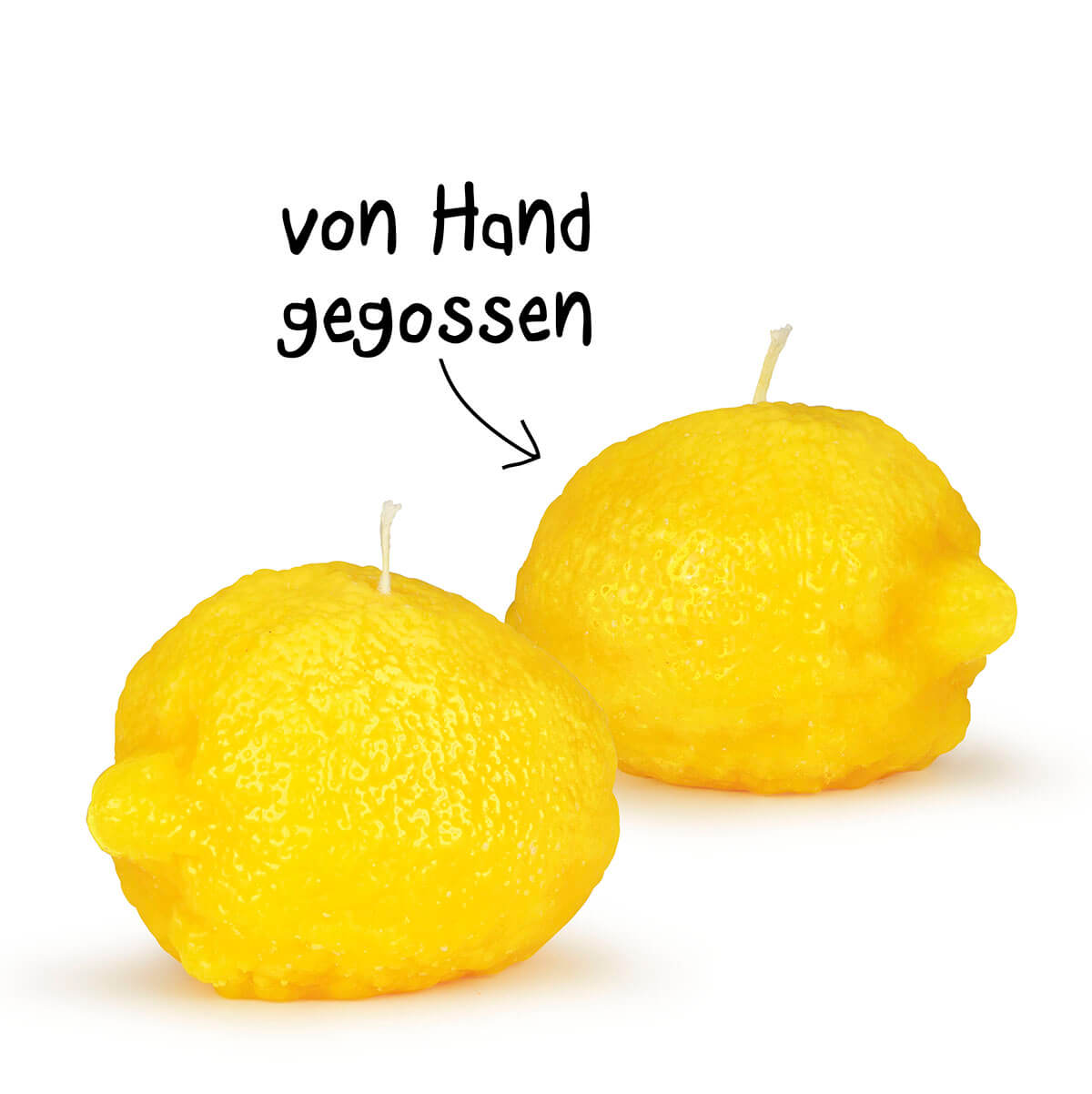 Due candele giallo brillante a forma di limone, con superficie che imita la buccia naturale, leggermente ruvida. Su sfondo bianco, ognuna con piccolo stoppino. Una freccia scritta a mano «colata a mano» indica la produzione.